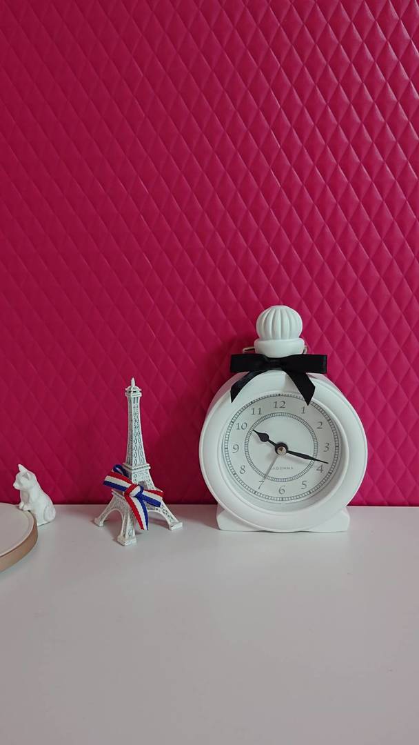 ビビッドピンクの壁に映える、真っ白な置時計。